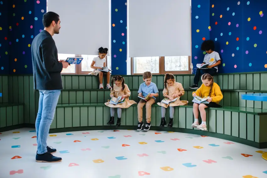 A group of children sitting on the floor and reading books.