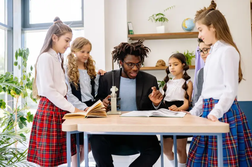 A group of young people standing around a table.